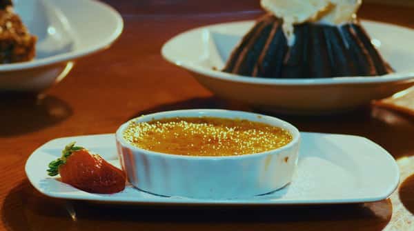 creme brule in a dish with a strawberry garnish
