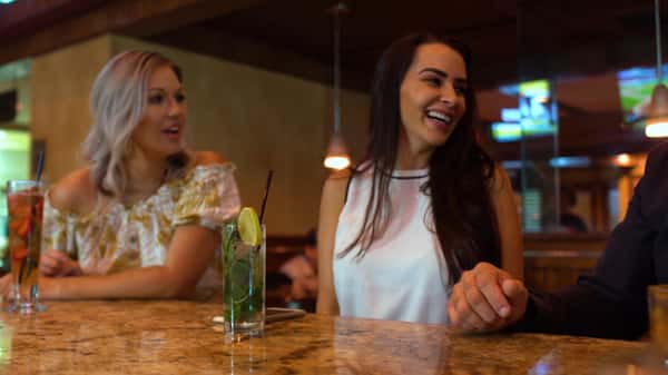 two women at the bar laughing with drinks on the counter