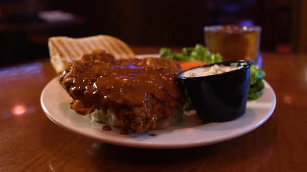 buffalo chicken sandwich on a bun with a side of bleu cheese