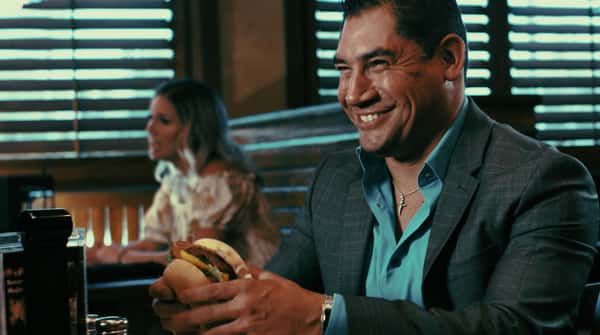 man with a handburger in his hand smiling
