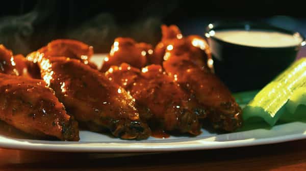 wings seasoned with hot sauce and a side of celery and ranch