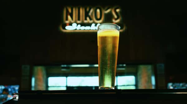 beer glass in front of a blurred, restaurant sign
