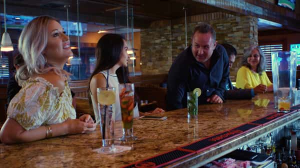 three friends at the bar with three drinks