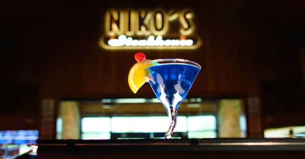 blurred out restaurant sign with a blue martini with a orange and cherry garnish