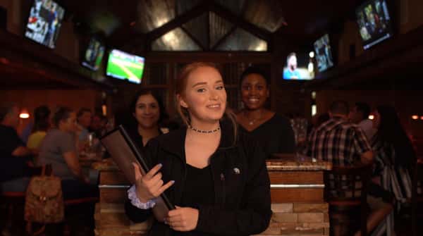 hostess greeting at the door with two other hostess behind her