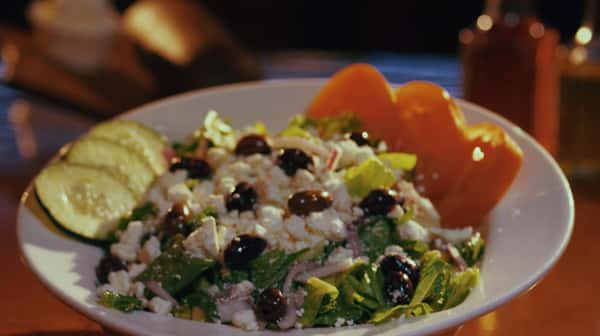 greek salad with olives, cucumbers and peppers in a bowl
