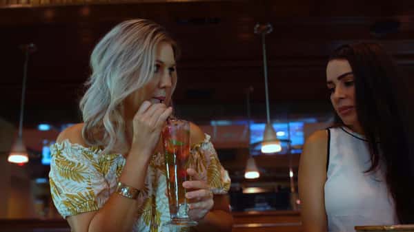 two women sipping their drinks at the bar