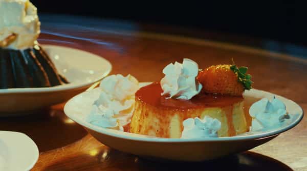 flan with strawberry garnish and whipped cream