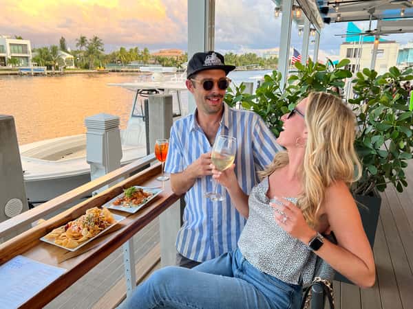 couple eating and drinking by the marina at The Cove