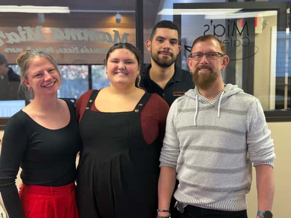 "Small group of restaurant managers from Hanover Mamma Mia's smiling at the corporate Manager Appreciation Breakfast, recognized for their leadership roles."