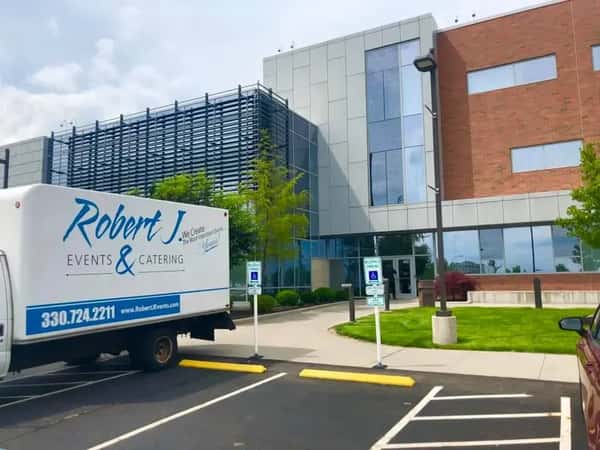 Robert J Events & Catering truck parked outside a modern office building, ready for an event setup.