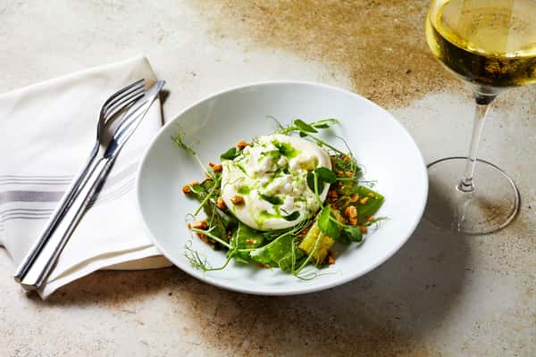 Burrata on table with fork and glass of wine