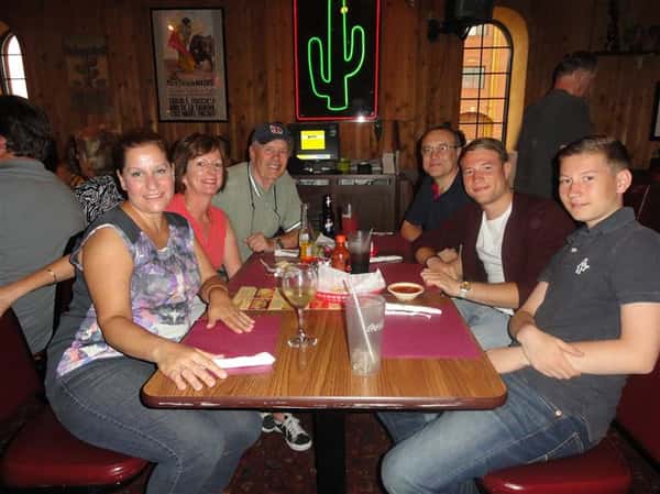 group photo of people smiling at dining table