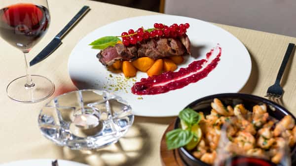 Steak with sauce and other dishes on the table