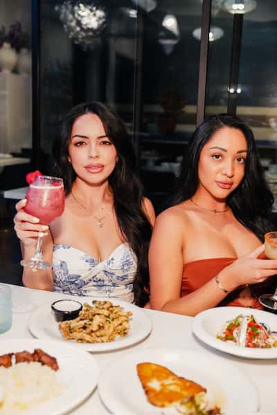 Two women drinking cocktails