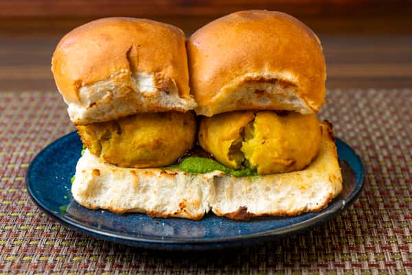 Vada pav — Indian street-style potato fritter sandwich served in soft buttered buns with green chutney.