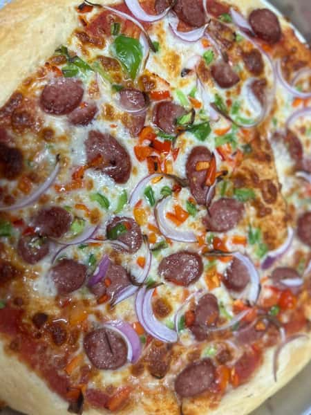 Sausage pizza from Elberta Pizza in Elberta, AL topped with sliced sausage, red onion, bell peppers, and melted mozzarella.
