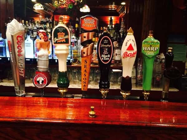 beer taps marking coors light, smithwick's, samuel adam's, blac & tan, bass, and harp lager