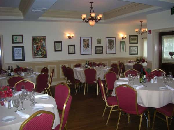 tables in a catering hall with 8 chairs and place settings per table