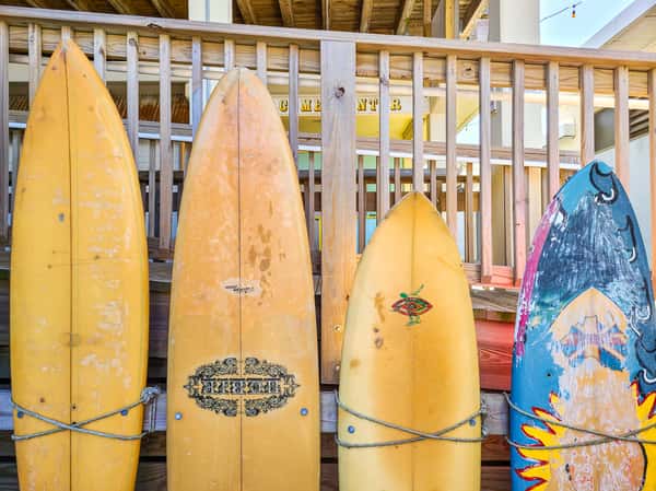 row of surfboards against deck railing