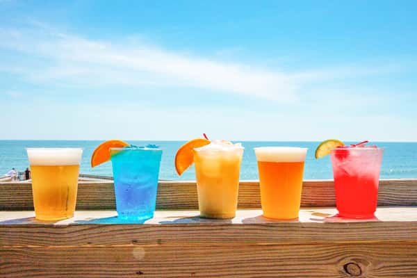 five tropical cocktails on deck railing