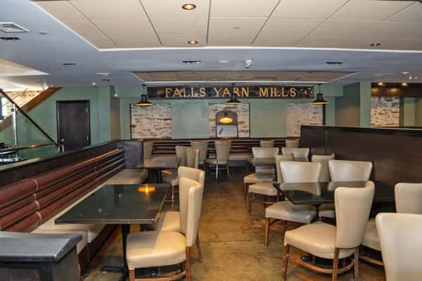upscale restaurant lounge with modern seating, warm lighting, and stone accent walls
