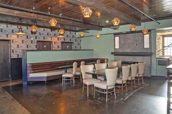 upscale lounge dining area with pendant lighting, booth seating, and rustic modern decor