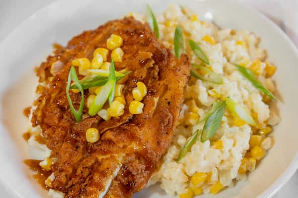 bourbon chicken bowl with creamy mashed potatoes, sweet corn, and green onion garnish