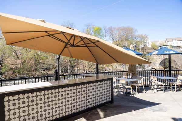 outdoor patio seating with umbrellas and scenic riverside restaurant atmosphere