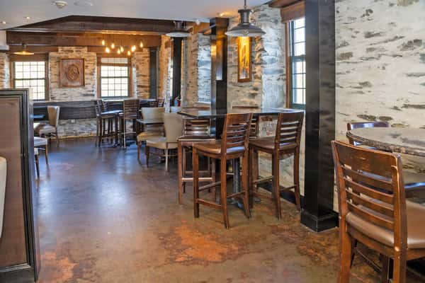 upscale restaurant lounge with modern seating, warm lighting, and stone accent walls