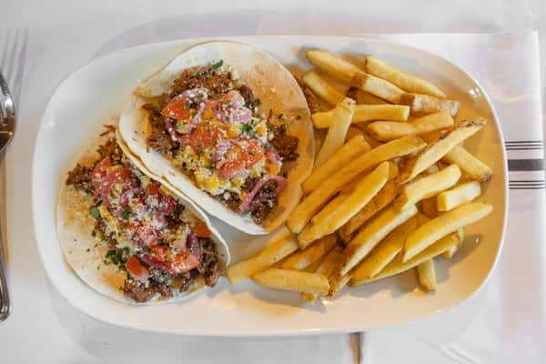 barbacoa tacos topped with fresh pico de gallo served with crispy french fries