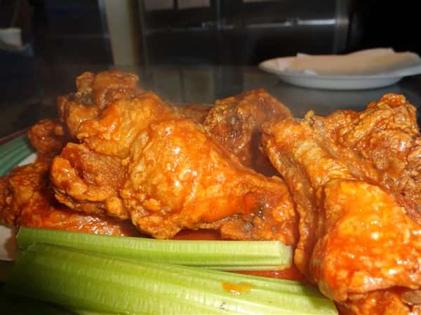 plate of buffalo wings with a side of celery sticks