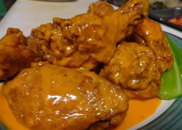 plate of buffalo wings with extra sauce