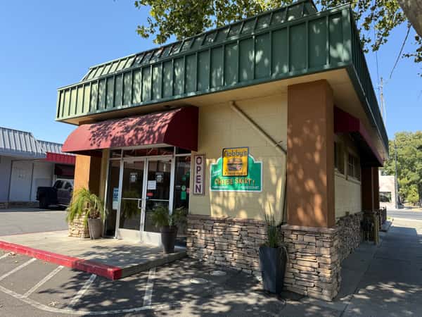 Exterior of Nobby's restaurant in Chico with a sign promoting its famous cheeseburgers and a red awning over the entrance.