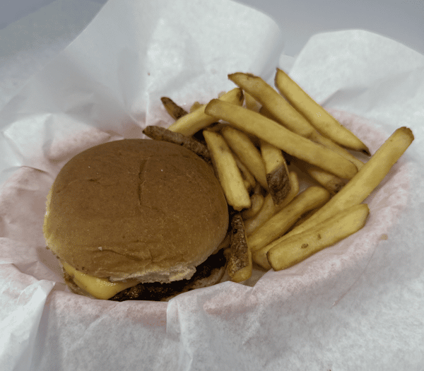 A cheeseburger with a beef patty, melted cheese, served with a side of French fries in a basket lined with paper.