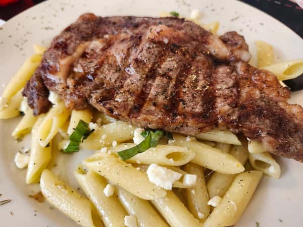 10oz ribeye stake served with penne pasta with garlic olive oil and basil.