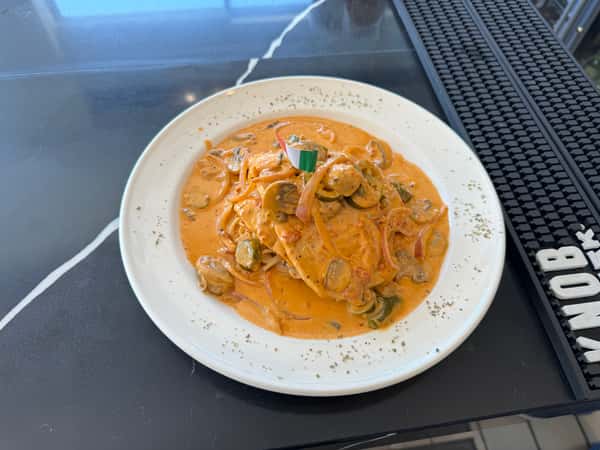 Chicken, mushrooms, onions, jalapenos over spaghetti pasta cooked with vodka sauce.