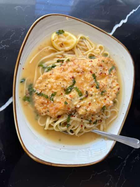 Lightly breaded chicken breast cooked in a lemon white wine sauce over linguine pasta.