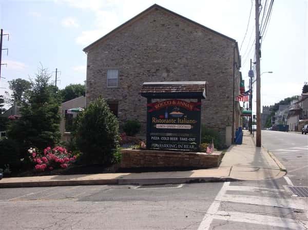 exterior brick building of rocco & anna's ristorante italiano with their signage next to the street