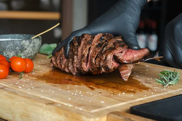 A man cutting a steak on a cutting board