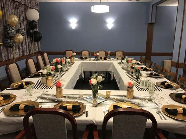 A large table with chairs and place settings set