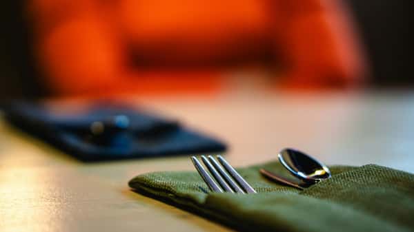 Close up shot of a fork, spoon, and knife in a napkin