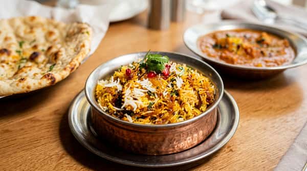 Fragrant chicken biryani with seasoned basmati rice, aromatic spices and fresh herbs in a traditional serving dish.