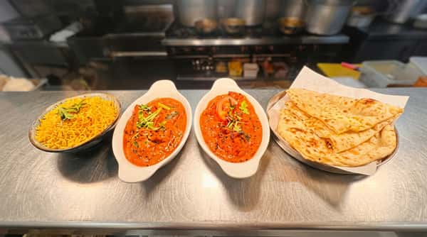Selection of colourful Indian curries with freshly baked naan bread and aromatic rice served together.