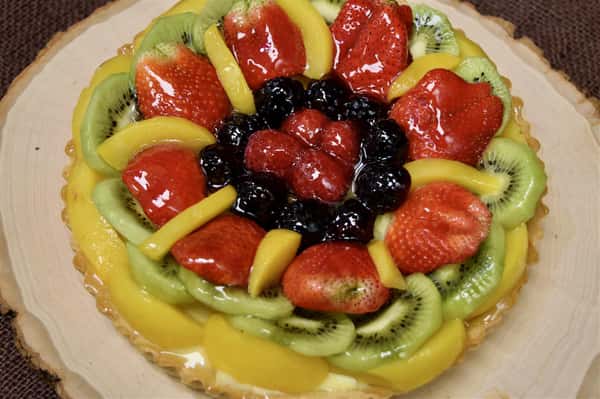 large fruit tart with assorted fruits and custard