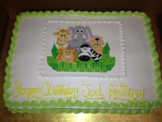 birthday cake printed with various animal faces in the middle