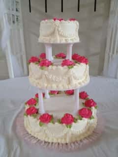 three layer cake with vanilla icing and roses