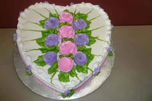 heart shaped cake with edible flowers in the middle of it