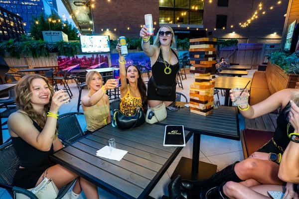 group of girls on the patio at The Rabbit Hole enjoying conversation, Jenga, and having a good time