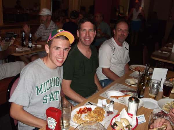 Men having dinner at the table and smiling for photo